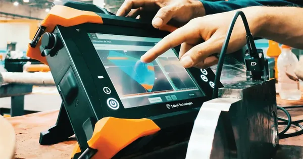 Técnico manipulando la interfaz de un equipo para realizar una inspección ultrasónica precisa y personalizada