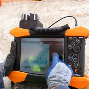 Ingeniero operando equipo de inspección ultrasónica para evaluar la integridad de un componente estructural en campo