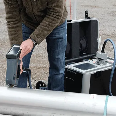 Técnico realizando espectrometría con dispositivo portátil en campo para análisis rápido de materiales metálicos en exteriores