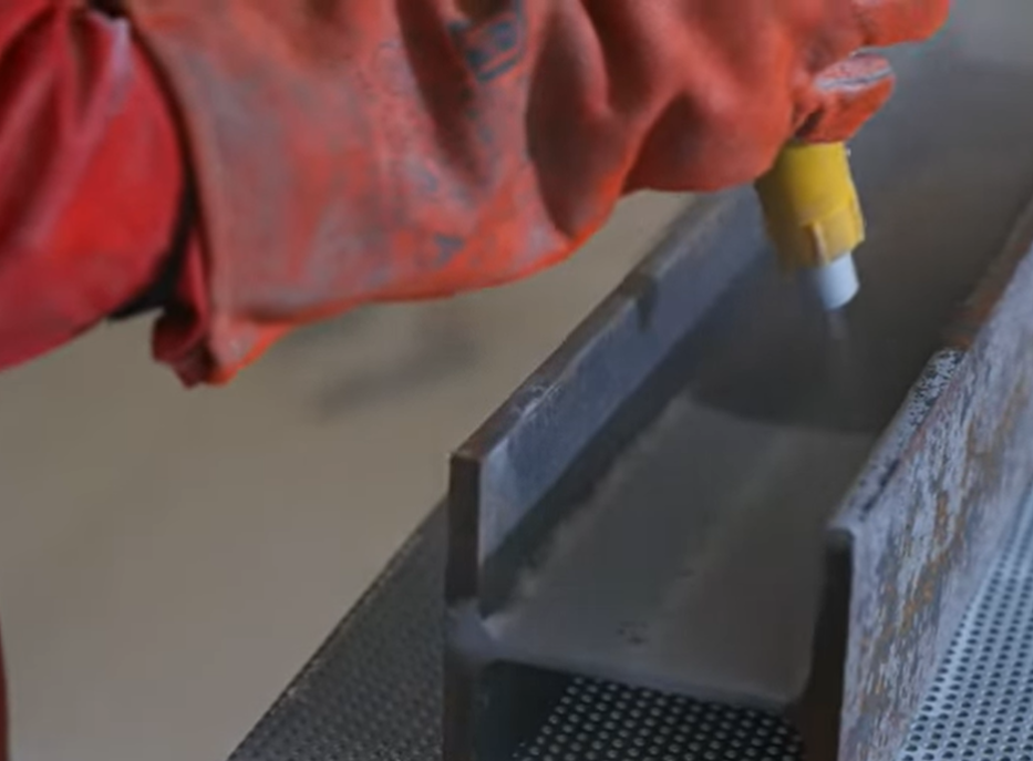 Vista de una sección de estructura con un recubrimiento de protección anticorrosiva en proceso, mostrando el resultado de una aplicación uniforme y efectiva sobre el metal.