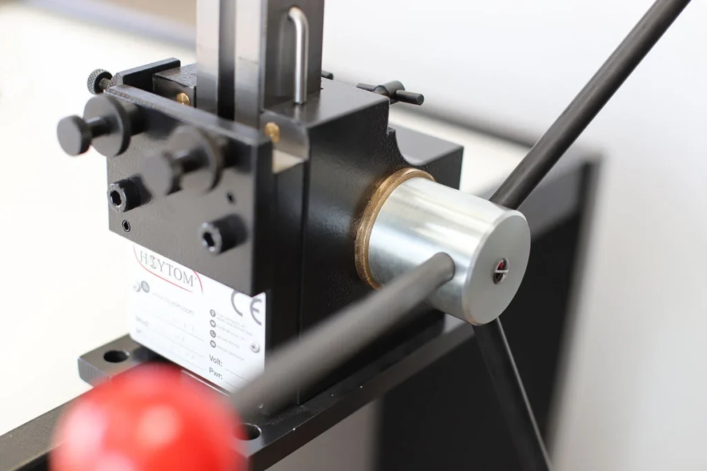 Primer plano de una brochadora manual de alta precisión, destacando su mango ergonómico y el sistema de fijación ajustable