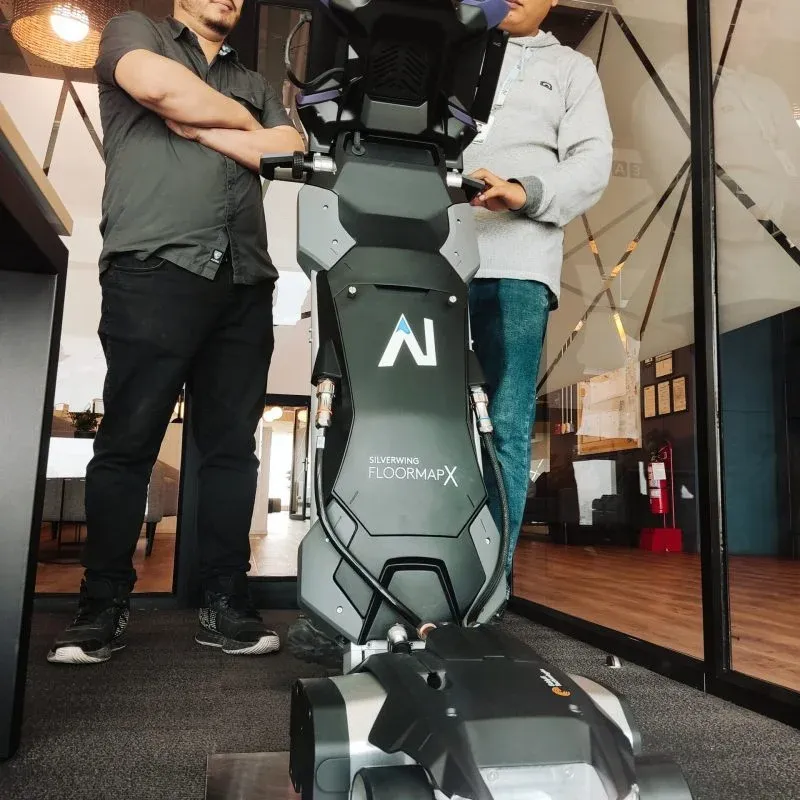 Dos operarios se encuentran junto a un equipo especializado "Silverwing FloorMapX" diseñado para Ensayos No Destructivos en grandes superficies de suelo.