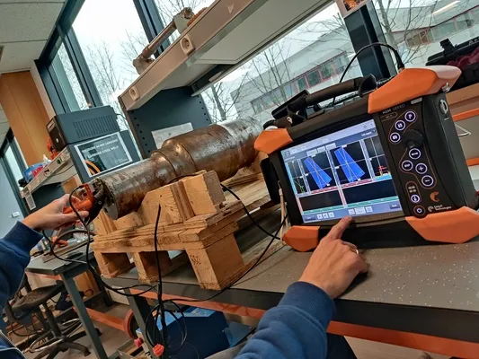 Técnico realizando un ensayo no destructivo con Ultrasonido Phased Array sobre un componente de acero de gran dimensión