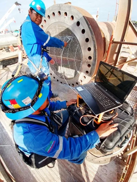 Técnicos de empresas de ensayos no destructivos en Perú evalúan la placa de tubos de un reactor en una refinería.