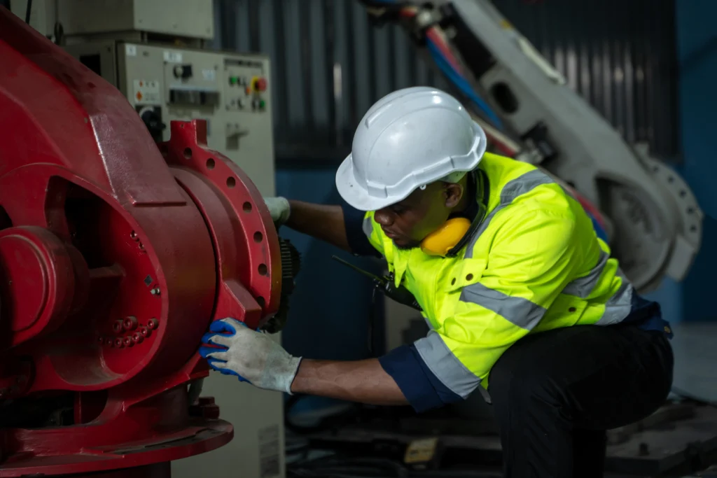 Mantenimiento industrial basado en riesgo: Operario inspeccionando una máquina para detectar problemas.