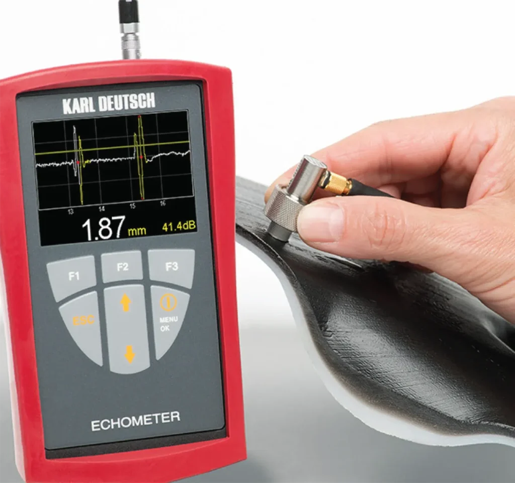 Pantalla del medidor de espesores por ultrasonido mostrando 1.87 mm durante una medición en metal.