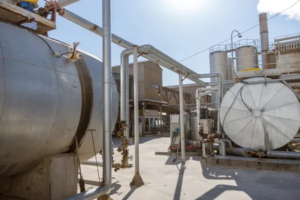 Grandes tanques de almacenamiento metálicos diseñados para el control de procesos industriales en una refinería.