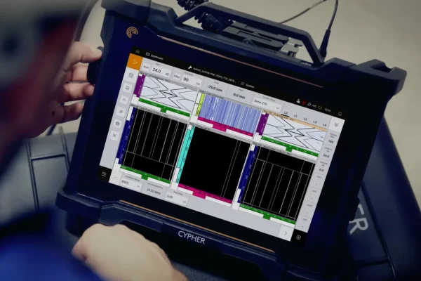 Operario analiza gráficos de ultrasonido phased array en la pantalla digital de un equipo portátil Cypher.